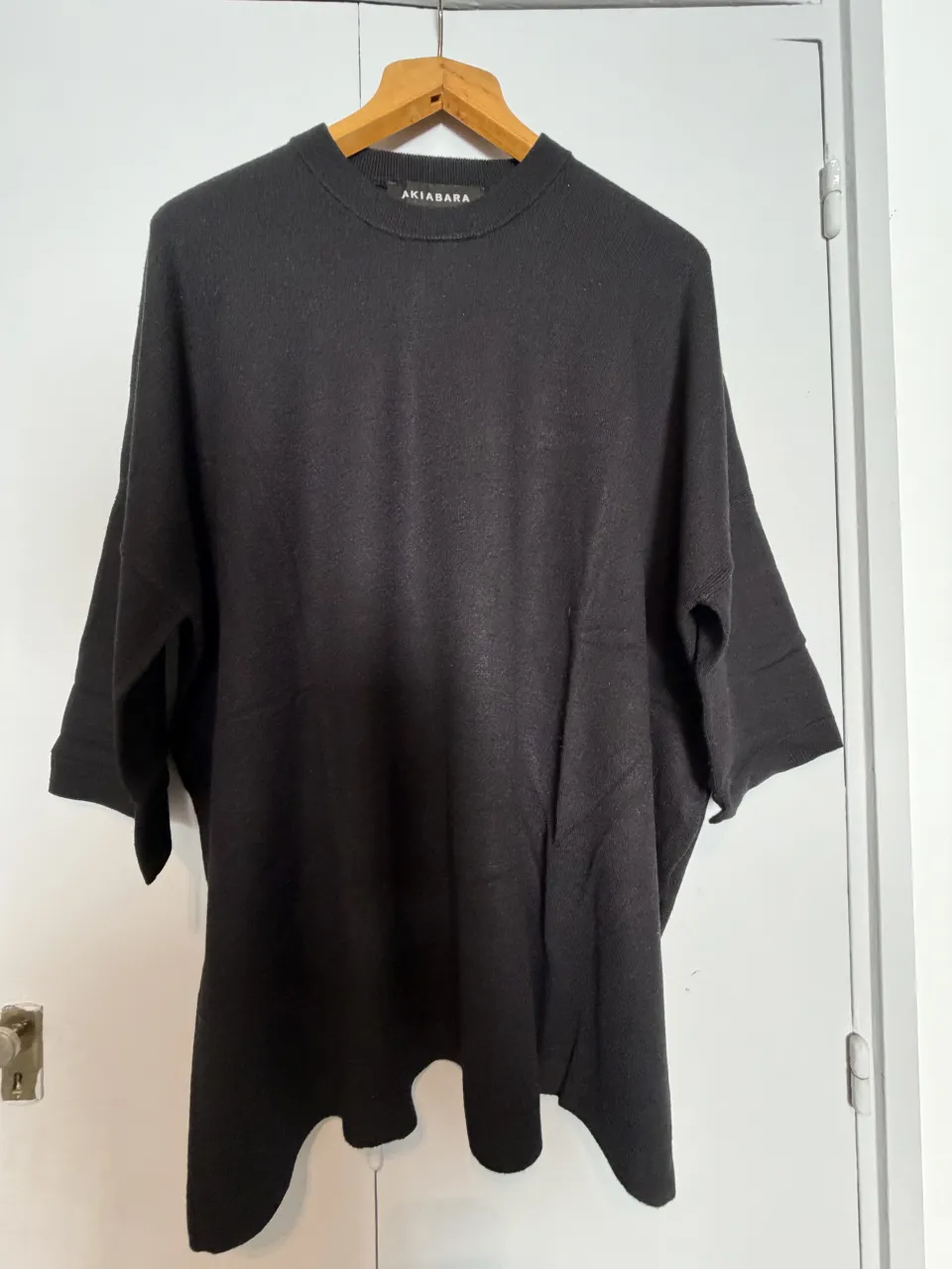 Sweater negro amplio de cuello redondo y mangas 3/4.