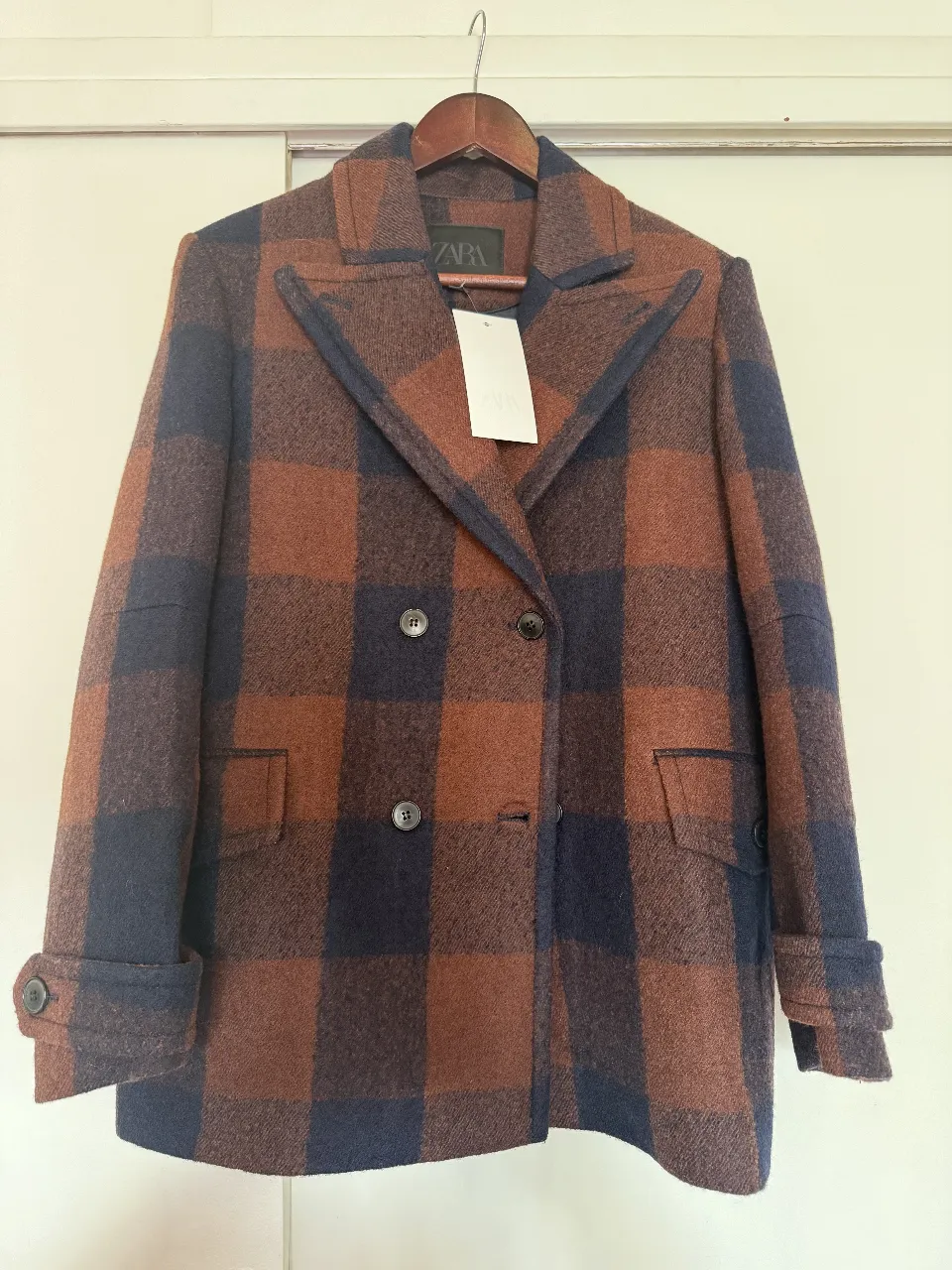 Tapado de paño a cuadros en tonos marrones y azul marino, de la marca Zara. Corte clásico con doble botonadura y solapas. Ideal para un look elegante y abrigado. 100% lana 