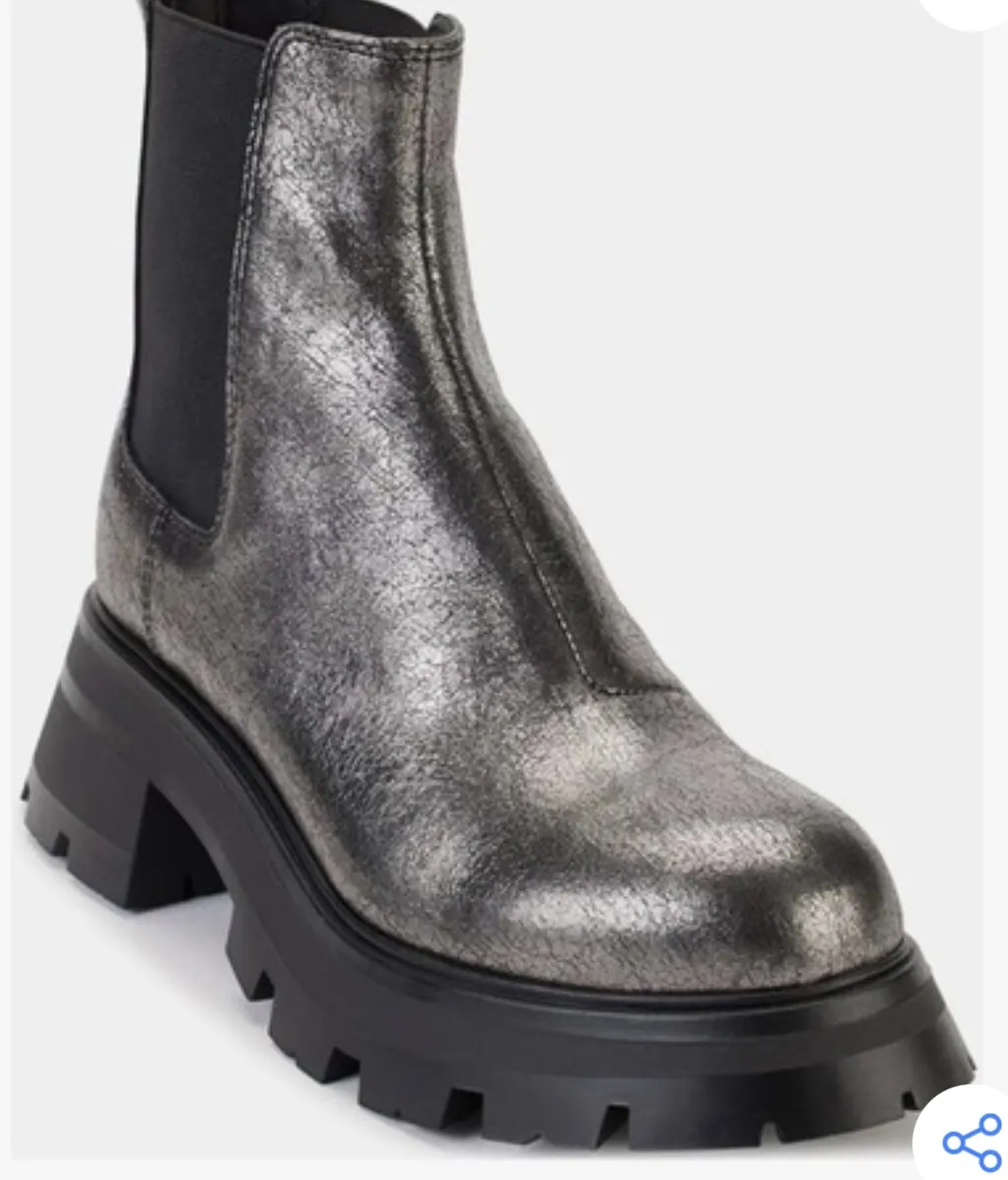 Botines de mujer DKNY plateados con suela track negra y cierre trasero con logo. Ideales para un look moderno y urbano.