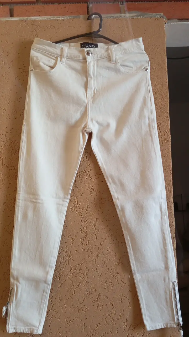 Jeans blancos de corte recto con cierre en los tobillos. Un clásico renovado para un look moderno y versátil.