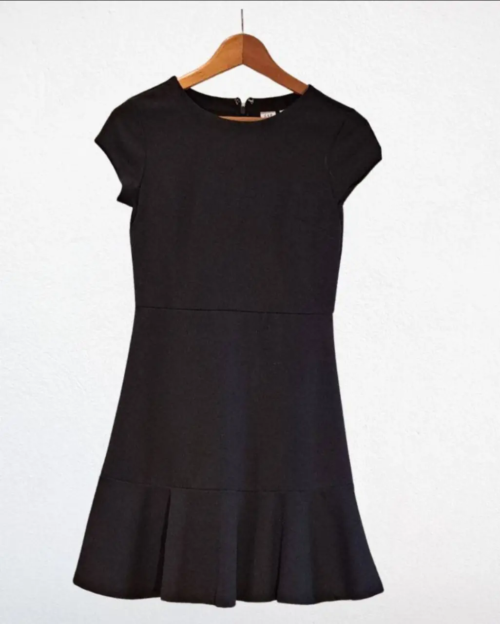 Vestido negro corto con corte en la cintura y falda con volados. Ideal para una salida o evento formal.