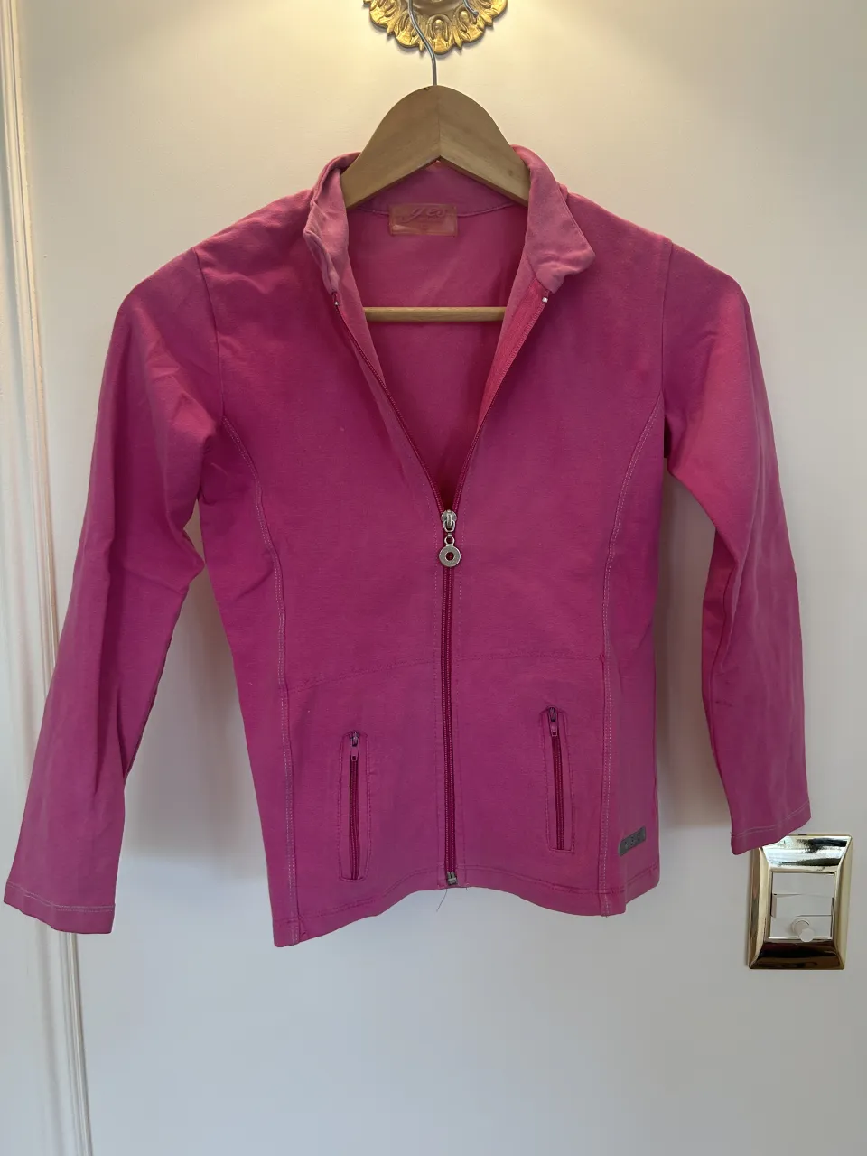 Buzo deportivo rosa con cierre completo. Tiene dos bolsillos frontales con cierre y puños en las mangas. La tela es súper elástica, es para niñas pero podría ser un S de mujer 