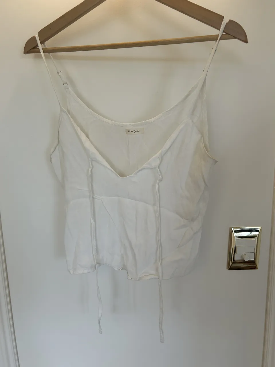 Musculosa blanca con tiras finas y escote en V. Posee cordones para atar en la parte delantera.