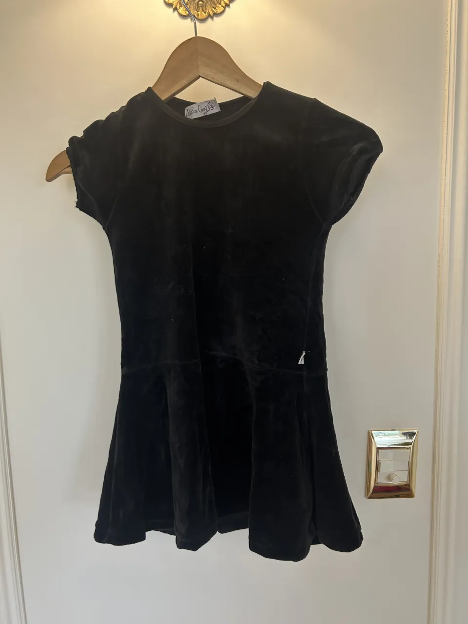 Vestido negro de terciopelo con mangas cortas y falda con vuelo.