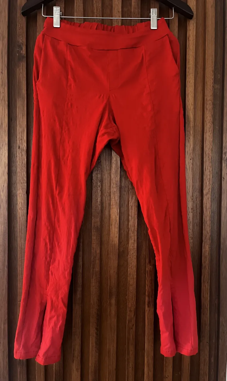 Pantalón 3/4 rojo de corte recto con tajos en el frente. Posee bolsillos laterales y cintura elastizada.