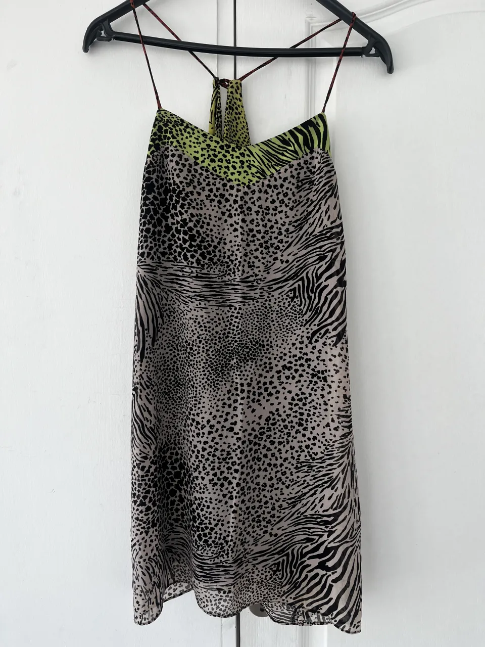Vestido estampado con múltiples motivos animales y detalles en verde lima. Diseño con breteles finos y escote halter, ideal para eventos de noche o salidas. Con otro vestido tipo forro abajo.
Talle 38/M