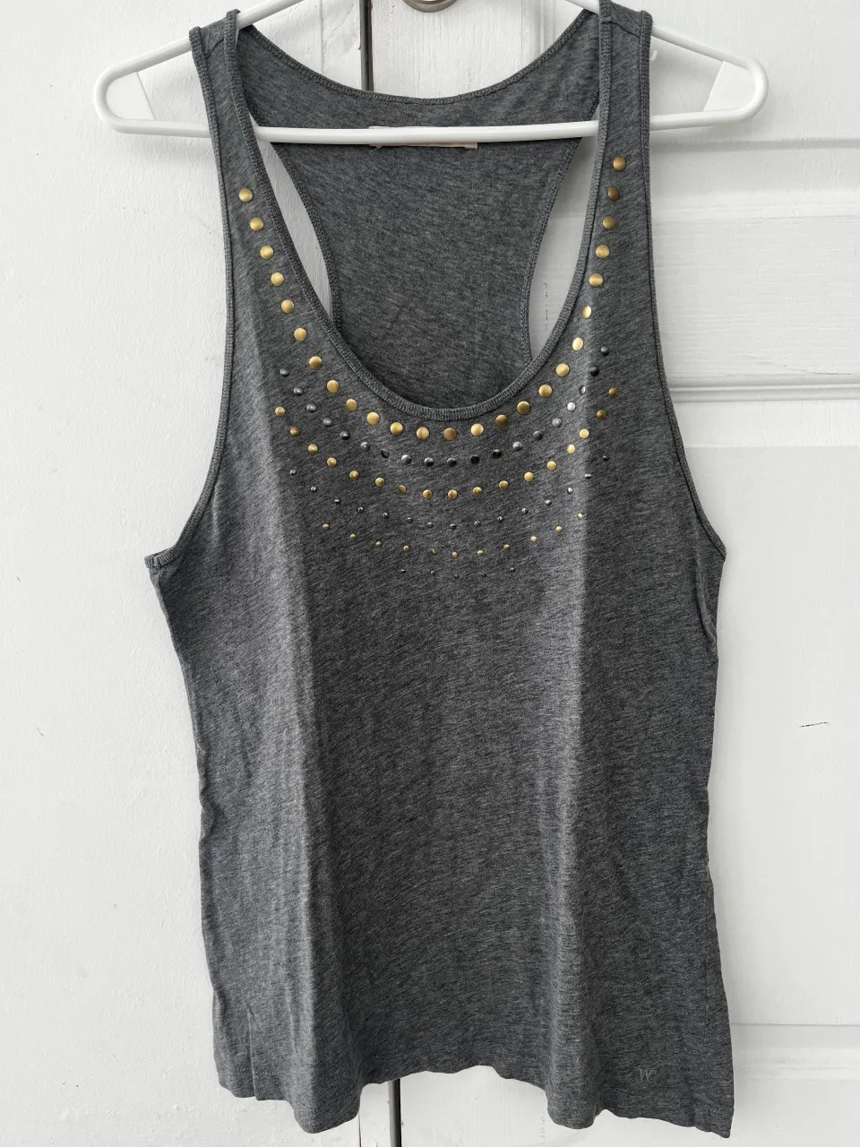 Musculosa gris con tachas doradas y plateadas en el cuello. Un diseño canchero y moderno para destacar tu look.
Talle 44/M