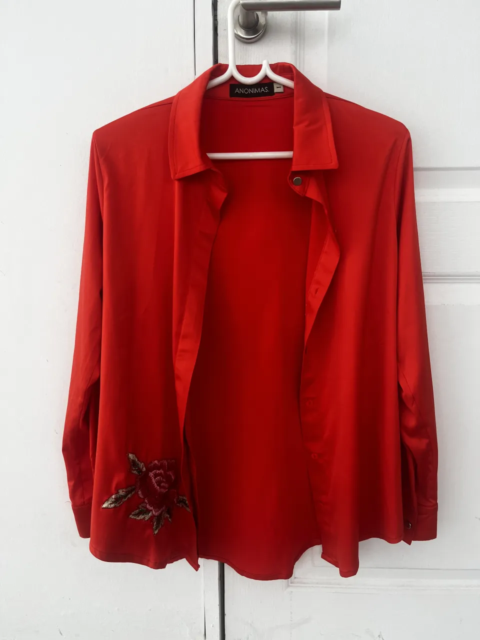 Camisa roja de manga larga con un hermoso bordado de rosa en la parte inferior izquierda. Perfecta para un look elegante y con un toque romántico.
Talle 1/M
