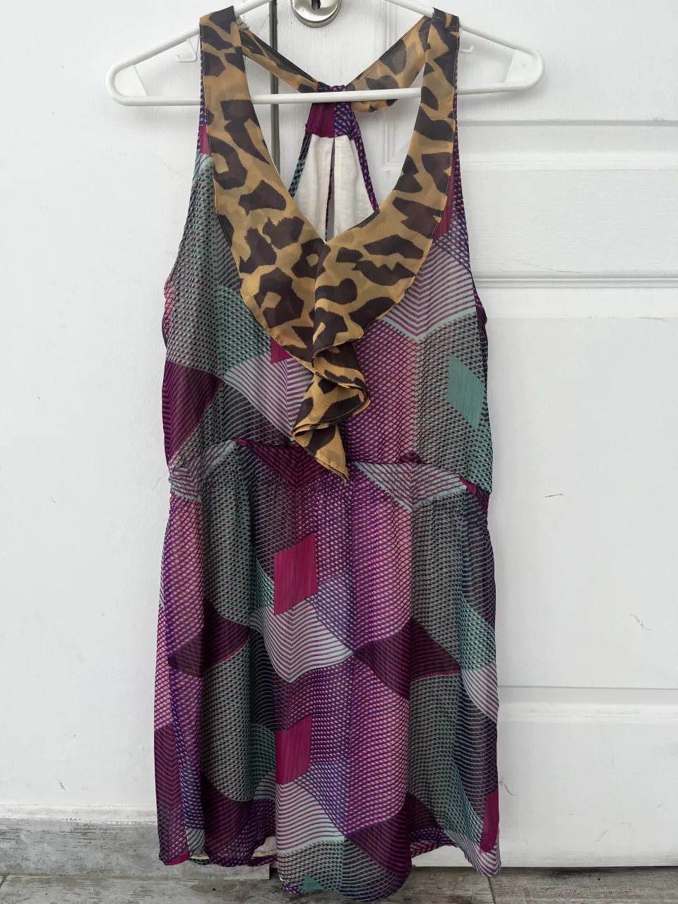 Vestido corto con estampado geométrico en tonos fucsia, verde y violeta. Posee un detalle de volado y estampa animal print en el cuello. Ideal para un look canchero y divertido.
El elástico de la cintura está vencido, hay que cambiarlo.