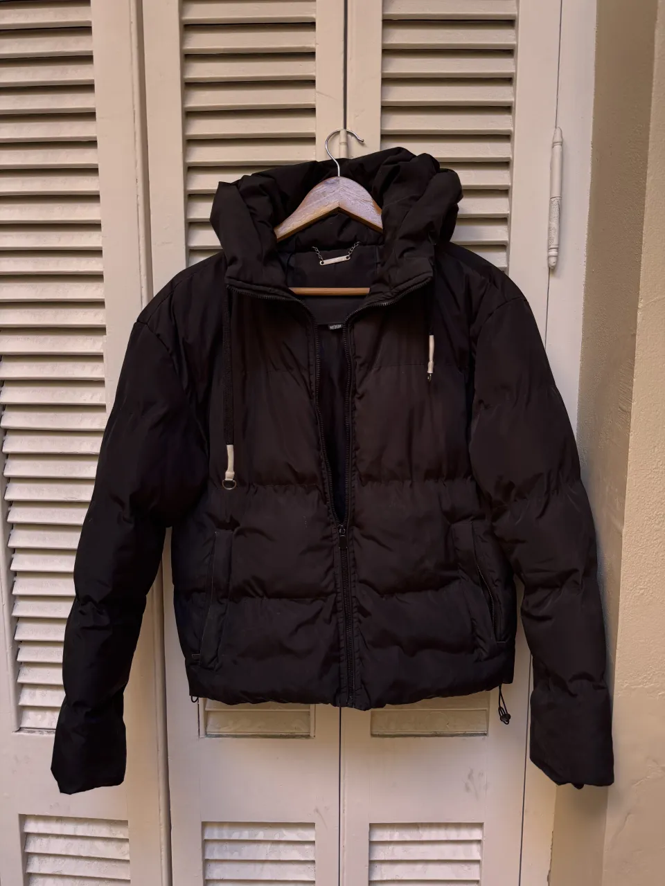 Campera puffer negra, súper abrigada y canchera. Tiene capucha y bolsillos. es corta. Ideal para los días fríos y para darle un toque moderno a tu look. 