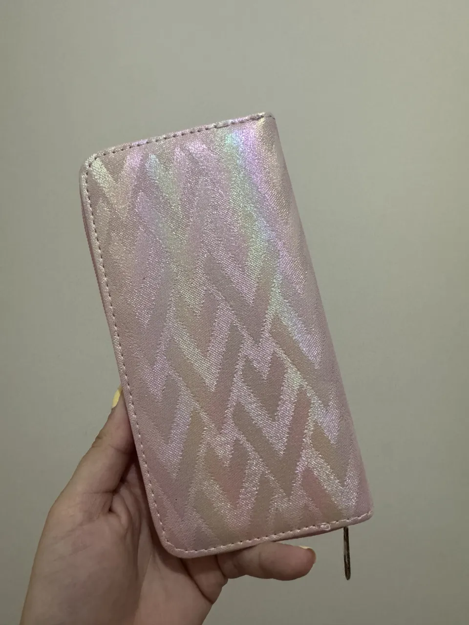 Billetera tipo sobre con cierre y diseño iridiscente en forma de V. Ideal para llevar tus esenciales con estilo.