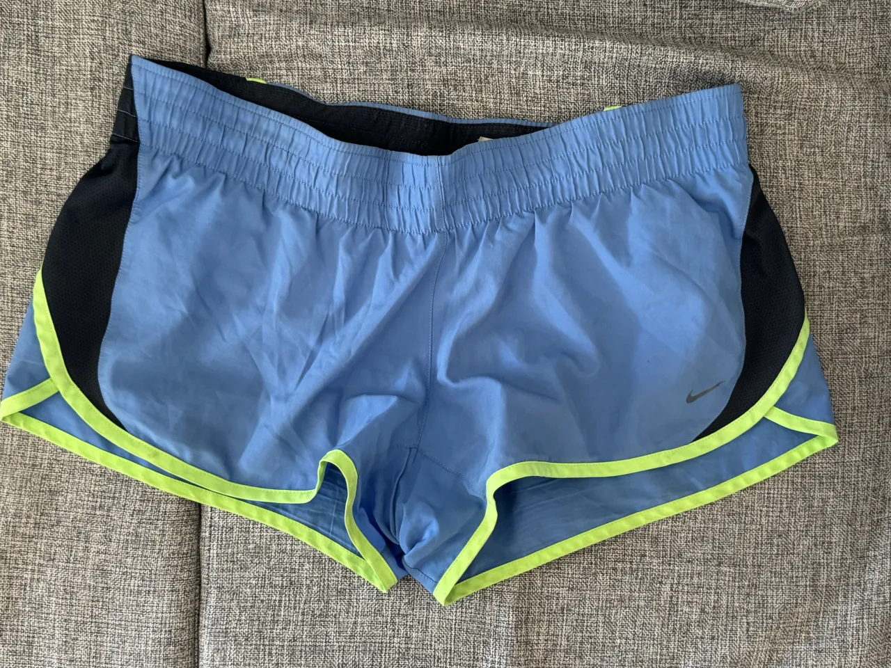 Shorts deportivos Nike, ideales para entrenamientos intensos. Confeccionados en tela liviana y transpirable, cuentan con detalles en negro y vivos en color verde flúo que le dan un toque moderno. Perfectos para mantenerte cómoda y ágil durante tu rutina. es talle L pero también va para un talle M. 