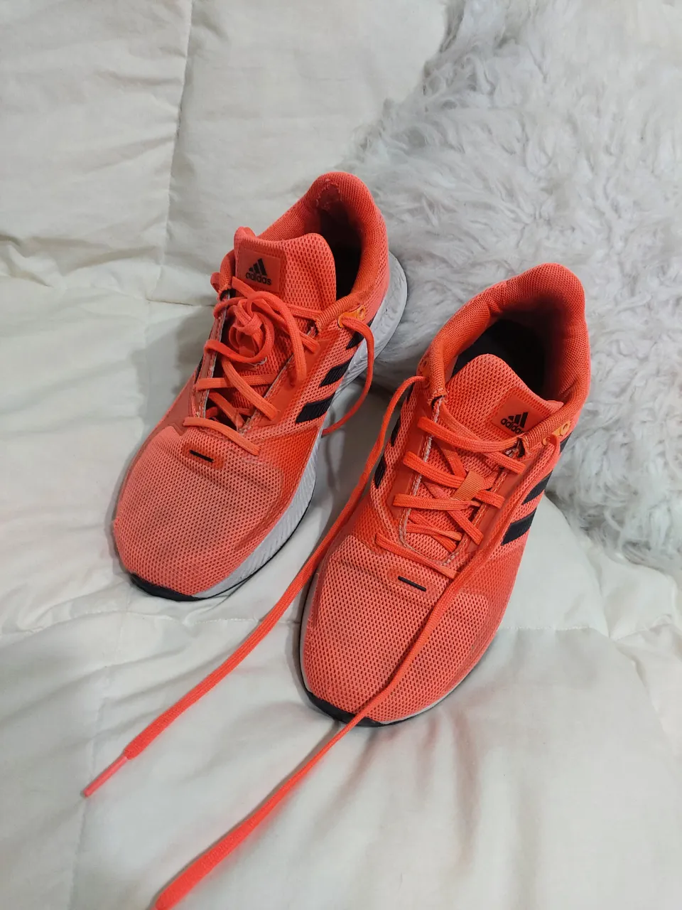 Zapatillas Adidas naranjas con detalles en negro, ideales para running y actividades deportivas. Tienen un diseño moderno y cómodo, perfectas para tus entrenamientos.