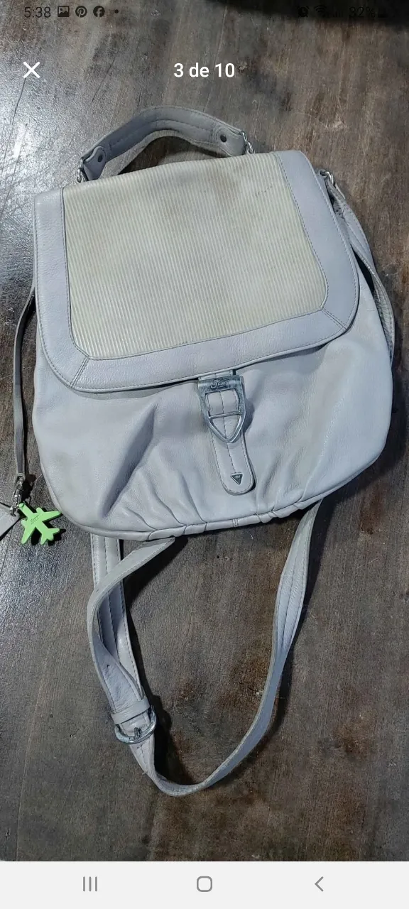 Cartera bandolera de cuero sintético gris claro con detalles en blanco. Diseño moderno y funcional, ideal para uso diario. Cuenta con correa ajustable y cierre seguro.