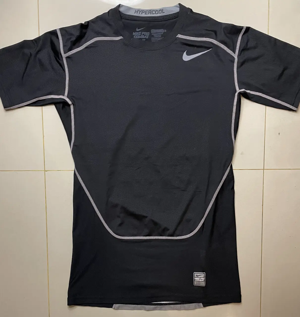 Remera deportiva Nike Pro Combat de manga corta para hombre, color negro con detalles en gris. Ideal para entrenamientos y actividades físicas.