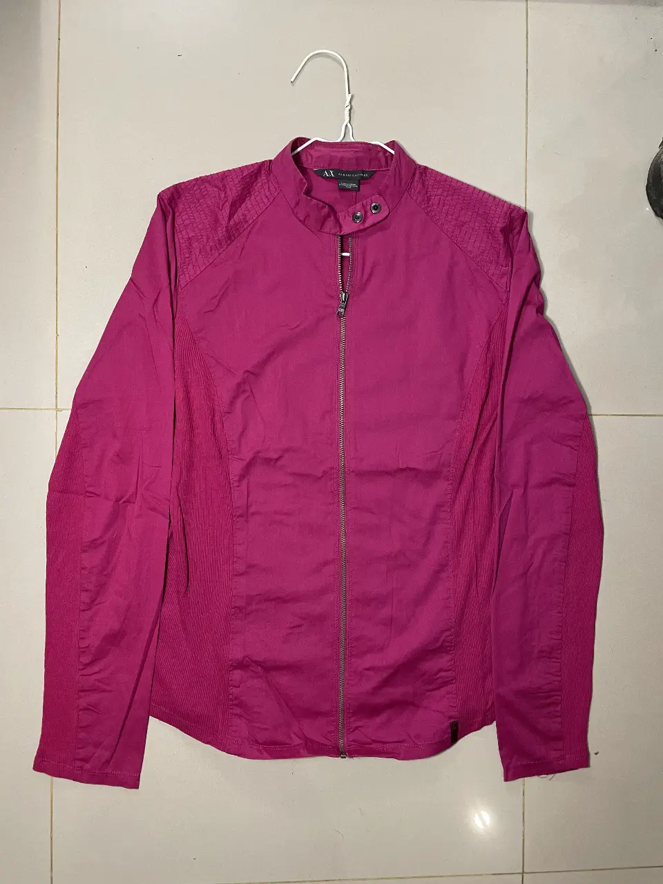 Chaqueta estilo biker de color rosa, con cierre y detalles en los hombros. Ideal para un look moderno y audaz.