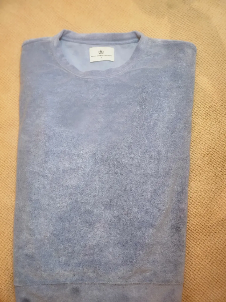 Buzo de color celeste con inscripción "Paula Cahen D'Anvers" en la espalda.