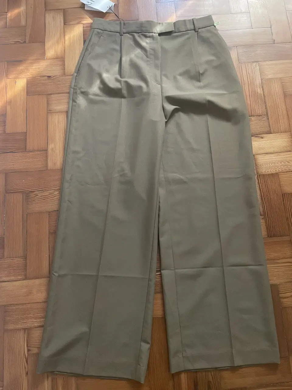 Pantalón sastrero de mujer, color verde oscuro. Corte amplio, tiro alto y pinzas delanteras. Ideal para un look elegante y moderno.