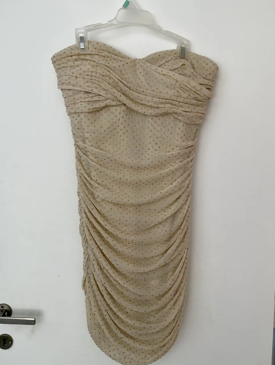 Mini Vestido strapless marca BEBE en color beige con detalles de strass dorados. Diseño drapeado y ajustado al cuerpo, con cierre metálico en la espalda, es un fuego. 
Tiene 1 único brillito defectuoso (foto 4).