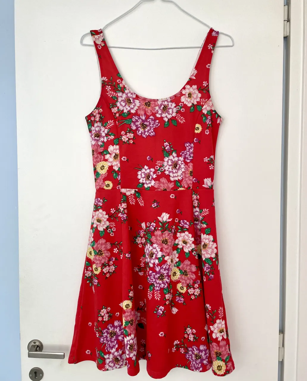 Vestido rojo vibrante con estampado floral super colorido H&M. Diseño sin mangas y corte skater con gran calce. El talle es un 38 de Europa.