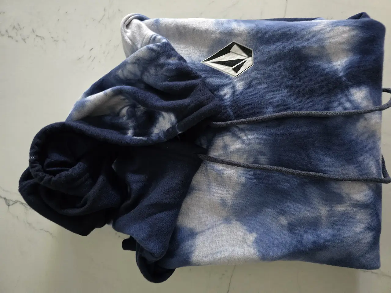 Buzo canguro Volcom tie dye azul y blanco, con capucha y logo bordado. Talle S.