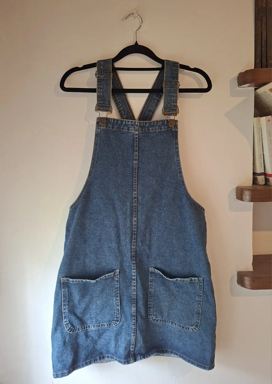 Vestido de jean con tiradores y bolsillos delanteros.