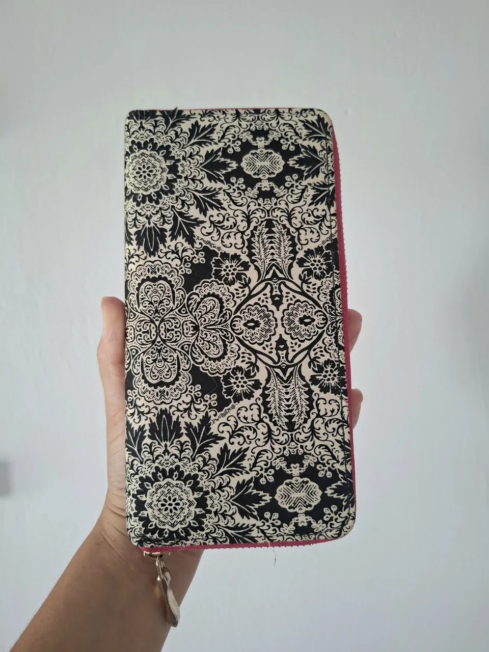 Billetera larga con cierre y estampa floral en blanco y negro. El interior es fucsia.