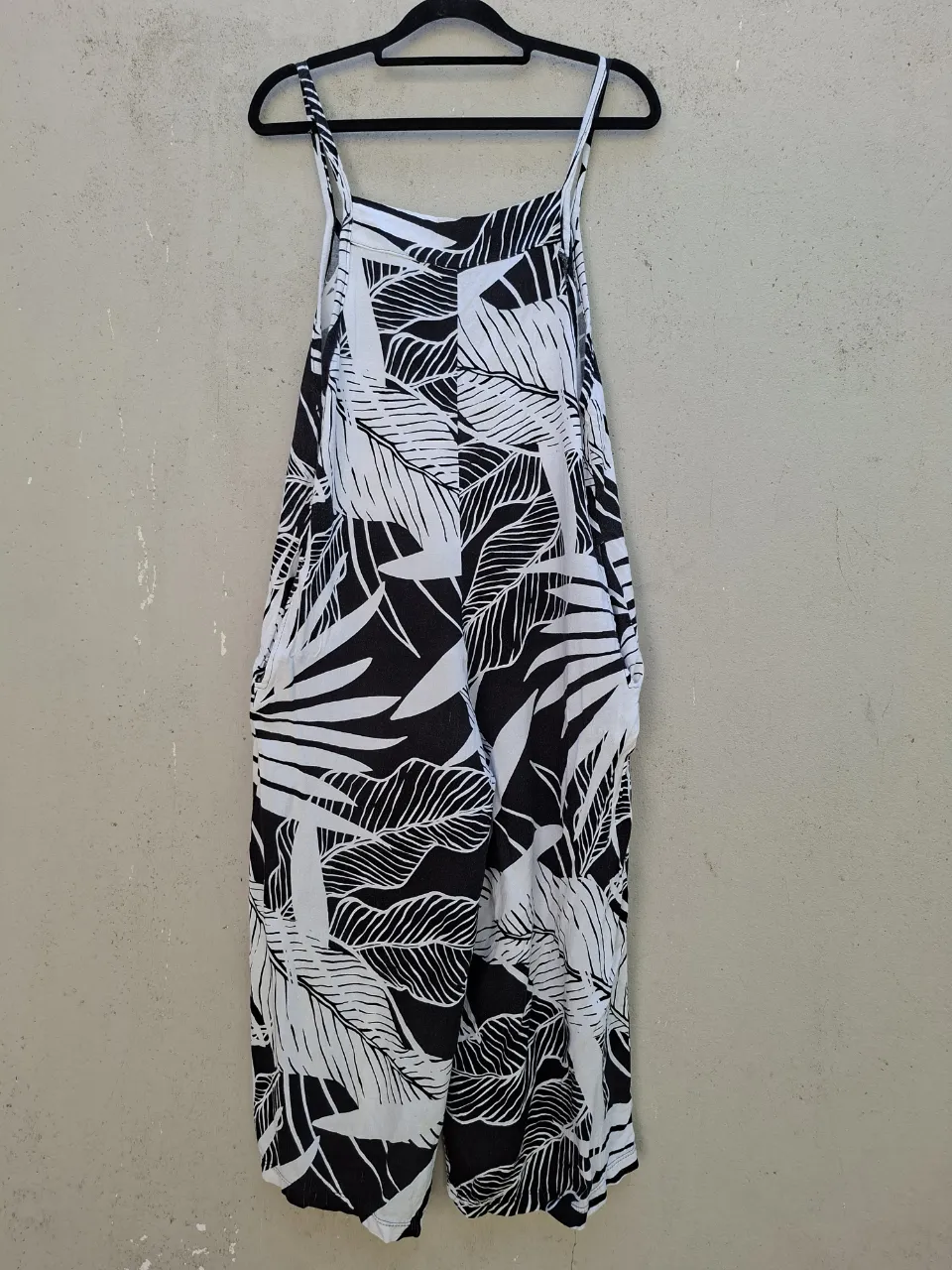 Mono estampado de hojas en blanco y negro con tiras finas y bolsillos laterales.