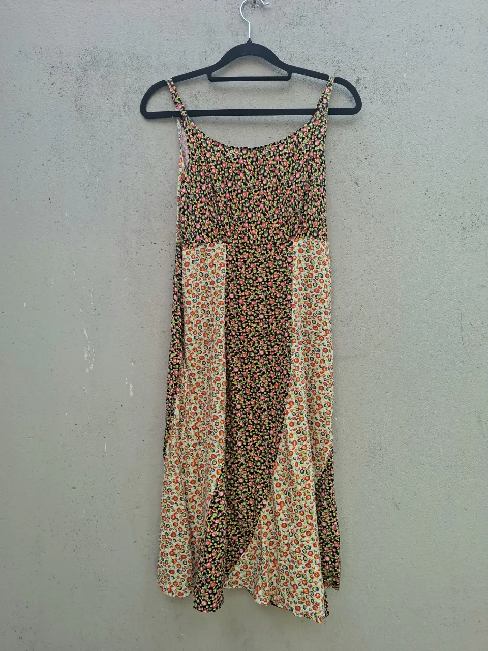 Vestido estampado floral con tiras finas. Posee recortes verticales con diferentes estampas.