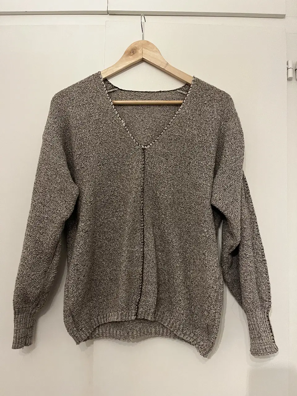 Sweater de lana tejido en V, con detalles de costura en el frente. Ideal para un look casual y abrigado. Talle unico. 