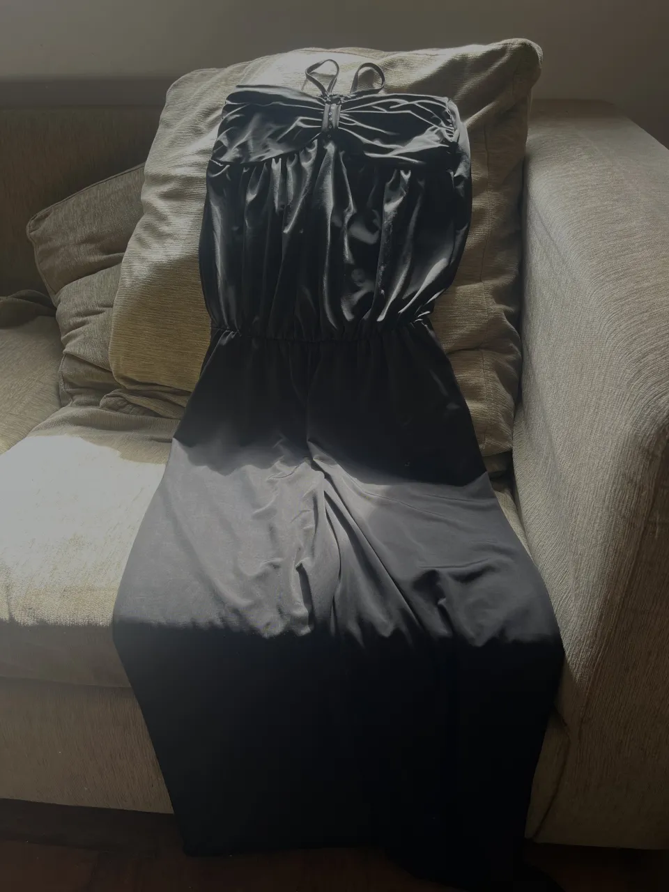 Vestido largo negro strapless con tiras finas y detalle de fruncido en el busto.