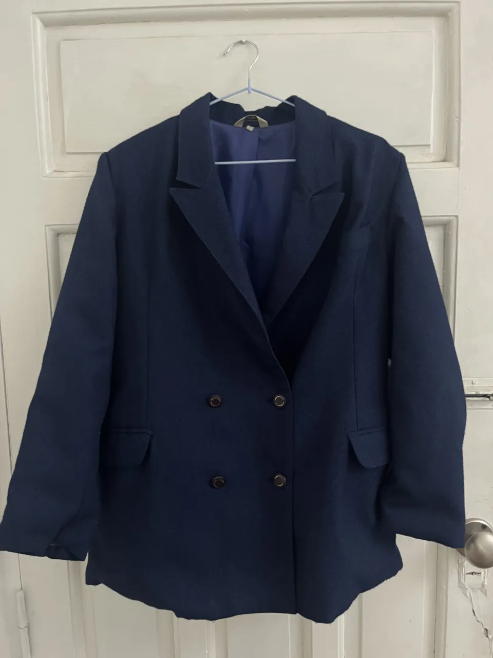 Blazer azul marino de vestir con doble abotonadura y bolsillos frontales. Se vende junto con un pantalón a juego.