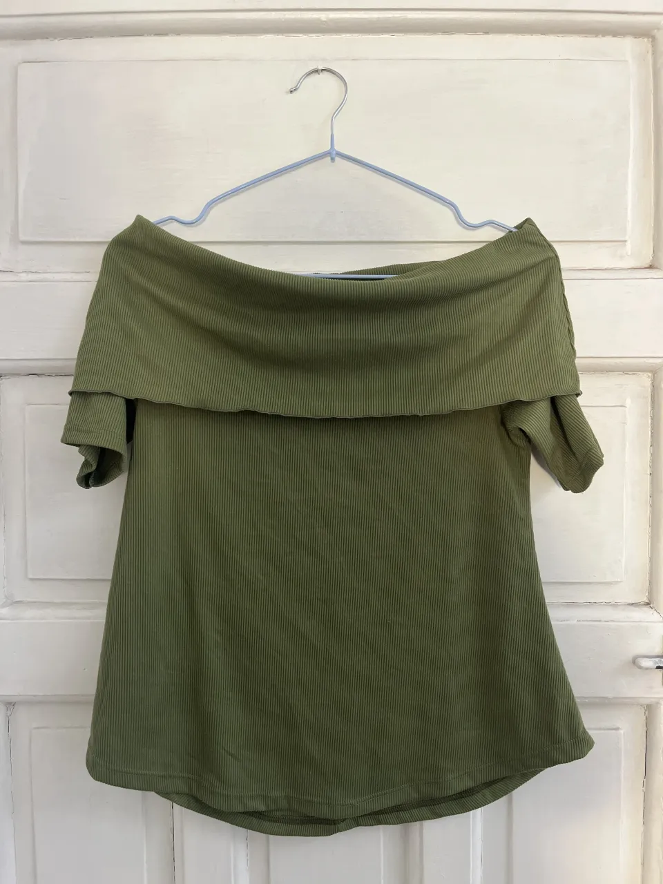 Remera verde militar, con escote Bardot y mangas cortas. La tela es acanalada.