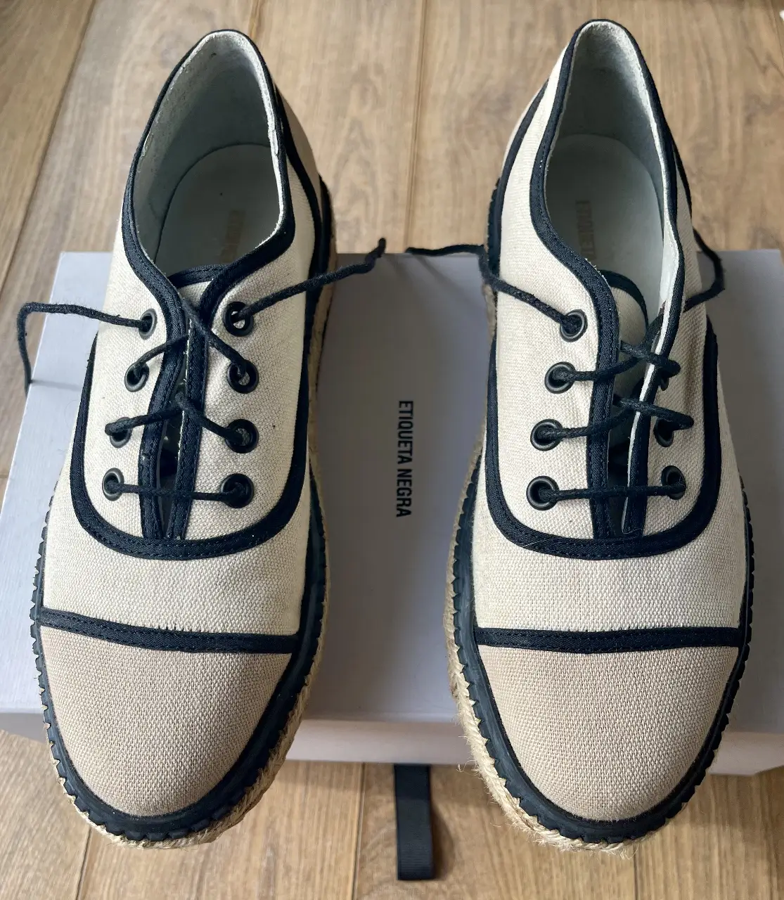 Zapatillas de lona color crudo con detalles en negro y suela de esparto. Ideales para un look casual y fresco.