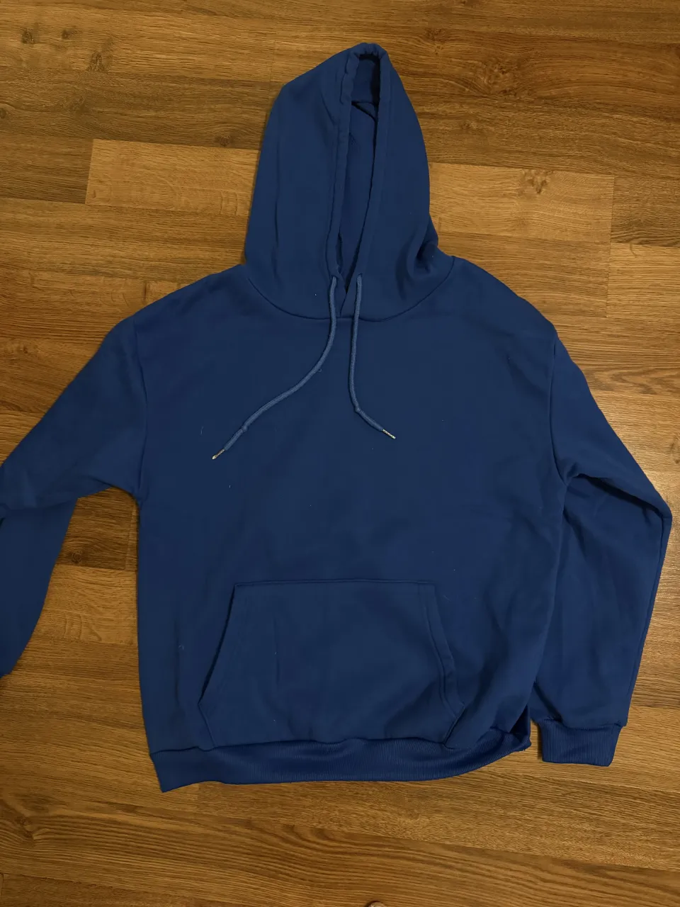 Buzo azul con capucha y bolsillo canguro. Ideal para un look casual y cómodo.