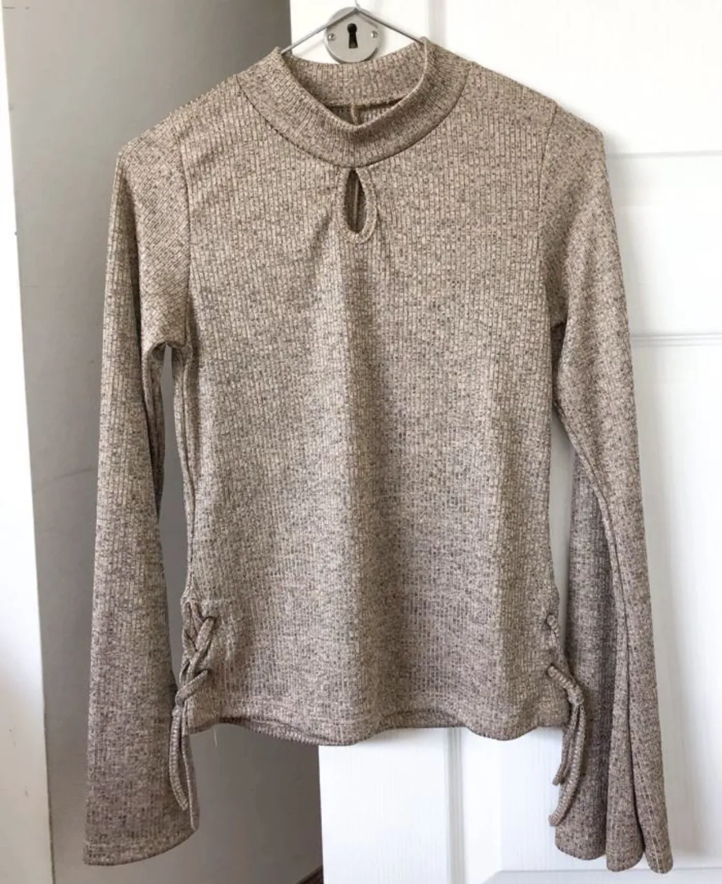 remera manga larga, viscosa, tejidita, el material es hermoso! el color no es dorado, es un champagne muy clarito, minimamente satinada, mangas acampanadas, cuellito redondo semipolerita, a los costados tiene un trenzadito que le da un detalle divino! medidas: largo 55cm, mangas 60cm, axila a axila 35cm