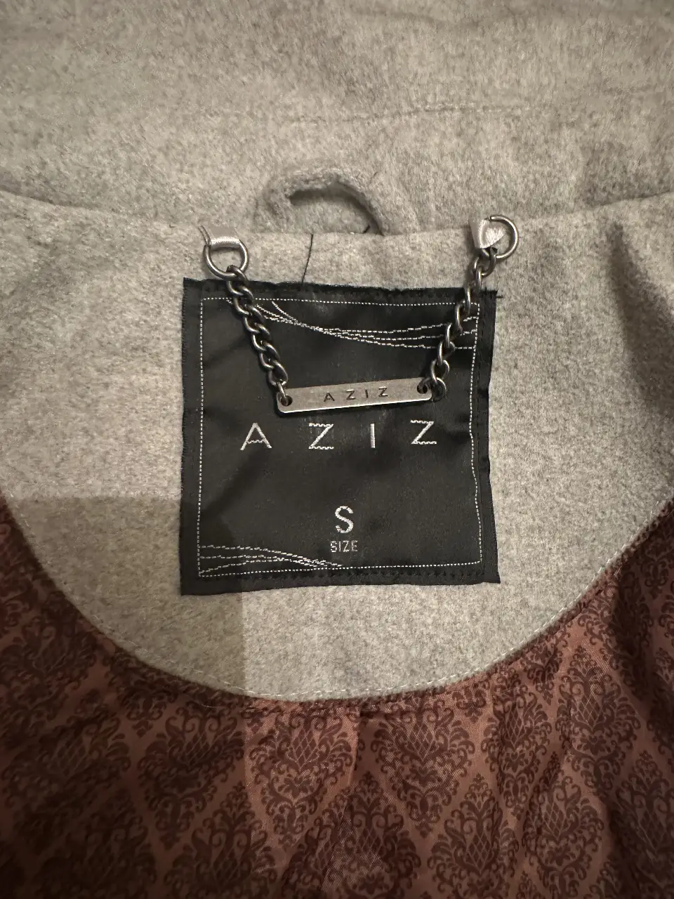 Tapado gris de la marca Aziz, talle S. Ideal para el invierno, con un diseño clásico y elegante. Perfecto para usar en salidas casuales o para el trabajo.