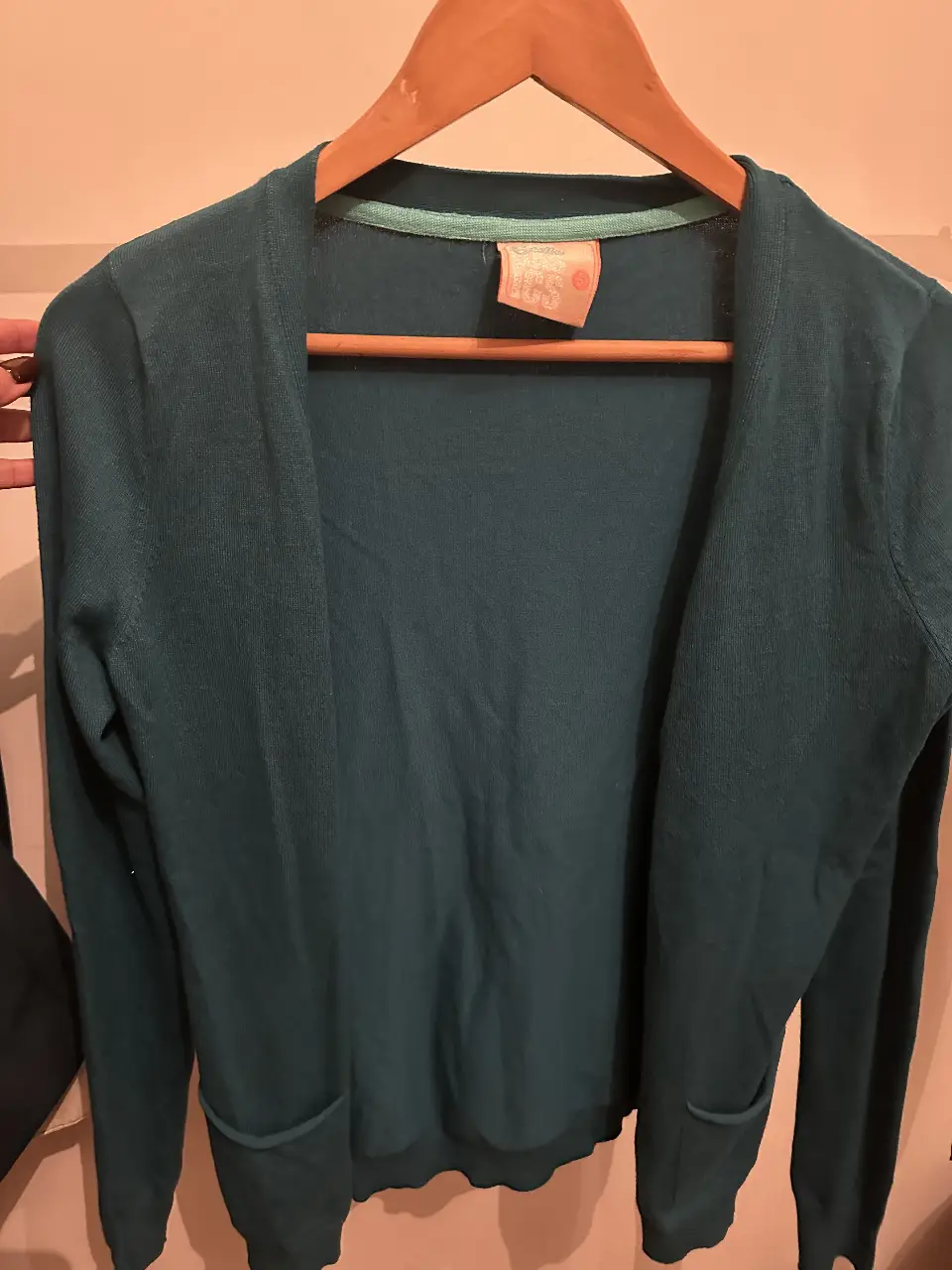 Cardigan de mujer de color verde oscuro, con dos bolsillos delanteros. Ideal para usar en otoño o invierno.