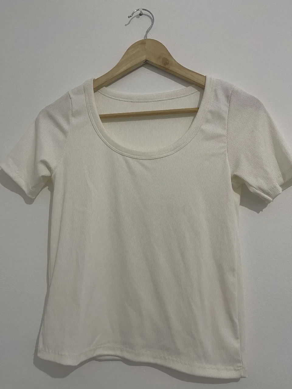 Remera blanca de manga corta, con cuello redondo y textura acanalada. Un básico súper canchero y versátil para tu día a día.