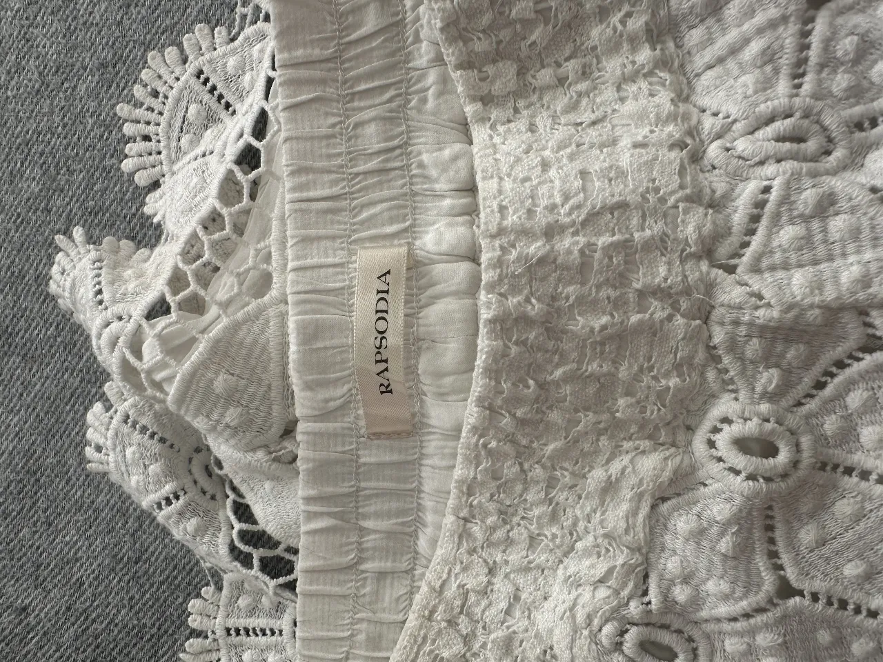 Top blanco de encaje de la marca Rapsodia, ideal para un look bohemio y romántico. Perfecto para combinar con jeans o faldas.