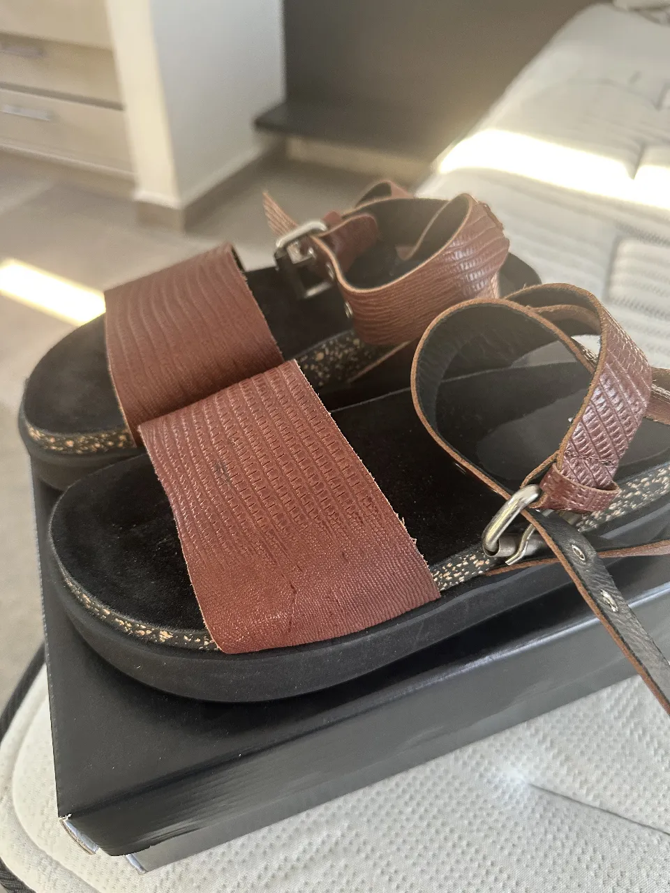 Sandalias de cuero marrón con suela de goma y detalles en corcho. Ideales para un look casual y cómodo.
