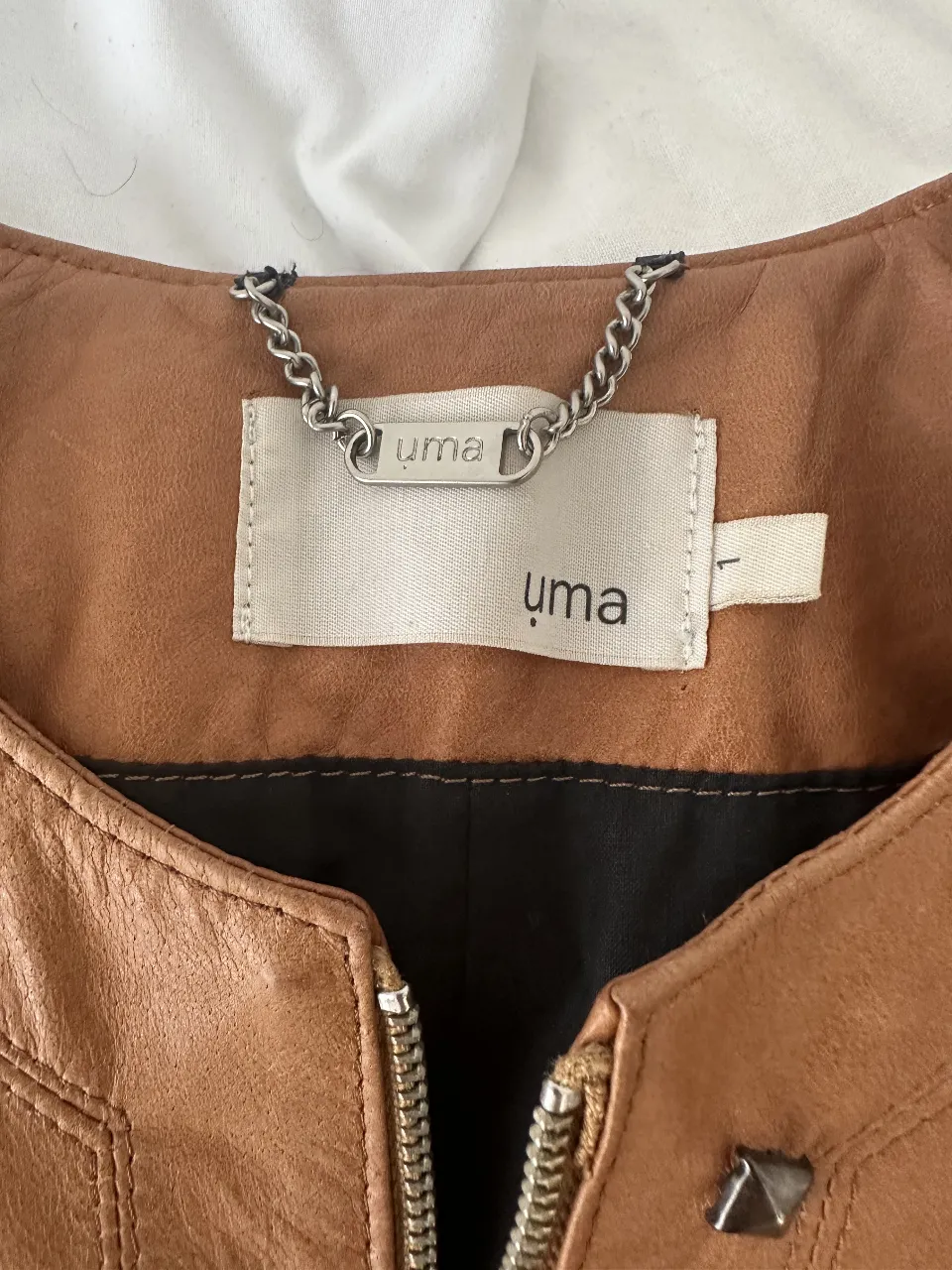 Campera de cuero marrón estilo biker para mujer, con detalles de costuras y cierre frontal. Marca Uma, talle L.