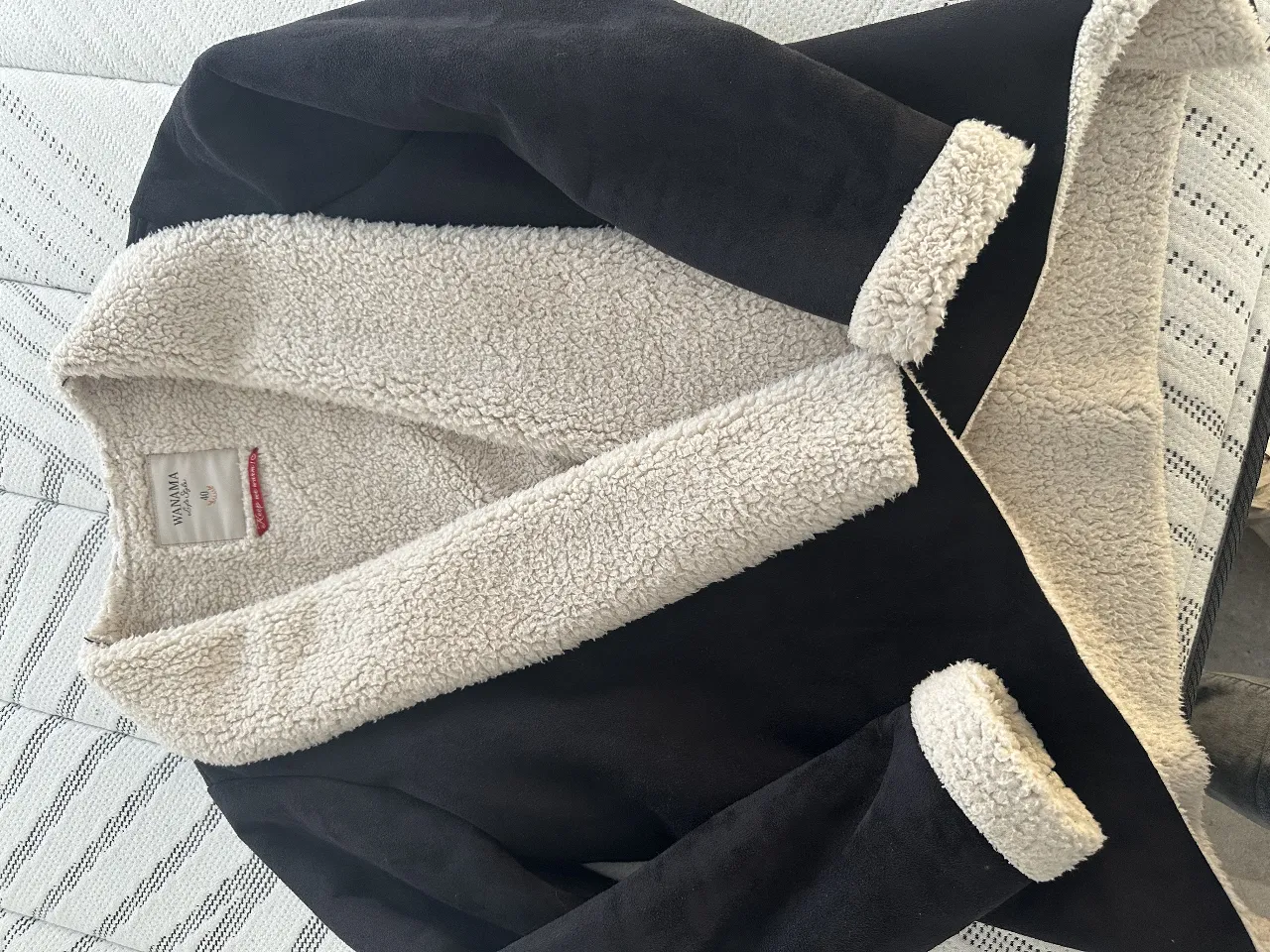 Campera de mujer tipo bomber, con interior de corderito color crudo y exterior negro. Ideal para el invierno, abrigada y con estilo.