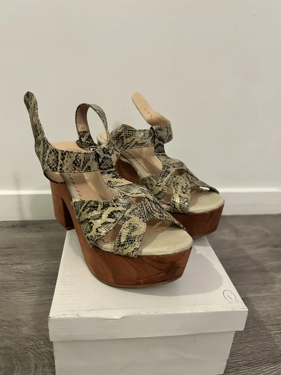 Sandalias de plataforma con taco de madera y estampado símil piel de serpiente. Ideales para un look de verano con estilo.