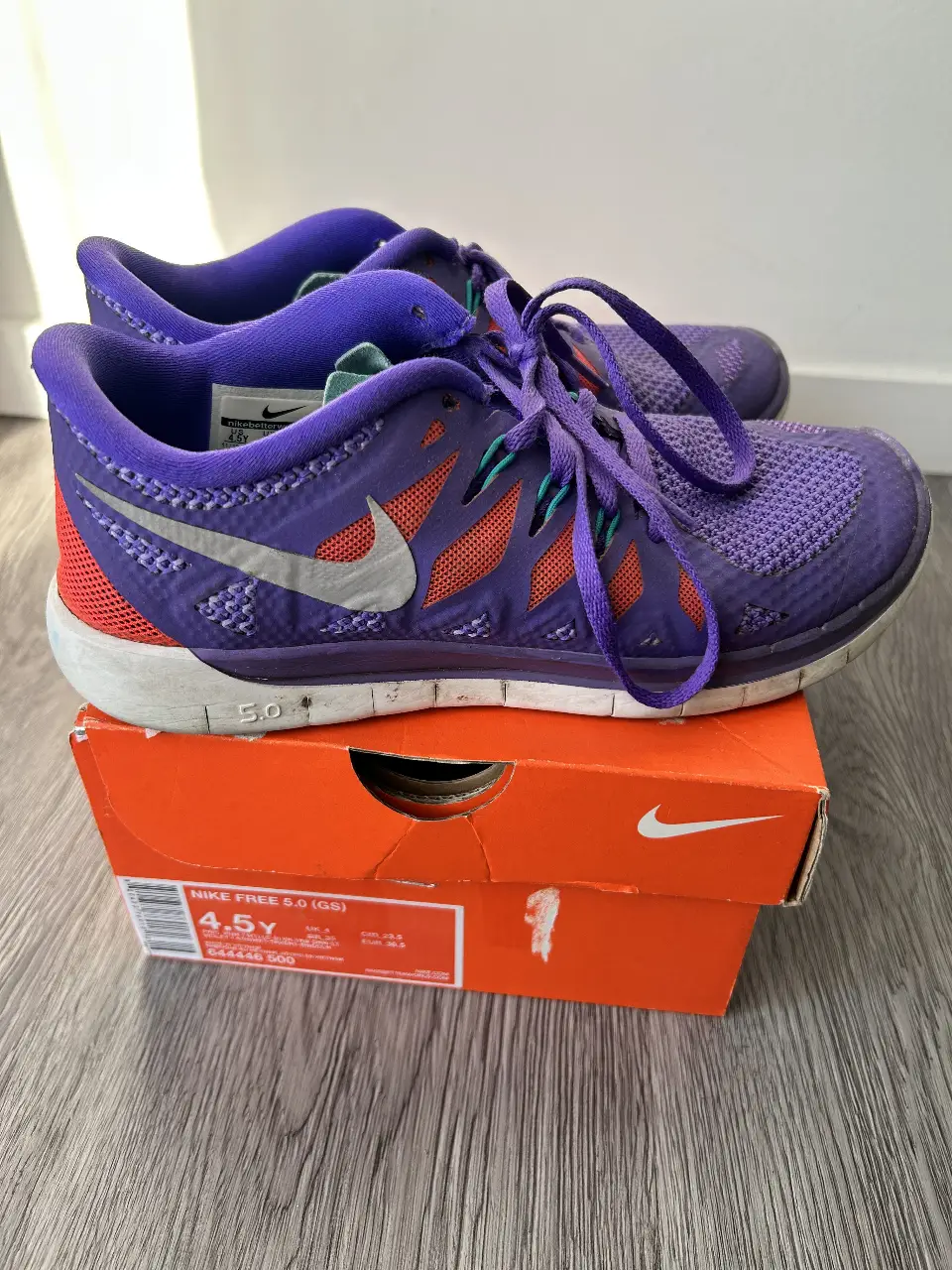 Zapatillas Nike Free 5.0 (GS) violetas con detalles en naranja y gris. Talle 4.5Y. Ideales para running y uso diario.