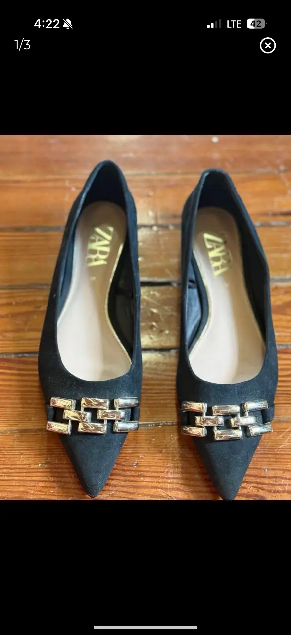 Ballerinas negras de gamuza con detalle de hebilla dorada. Marca Zara. Ideales para un look elegante y cómodo.