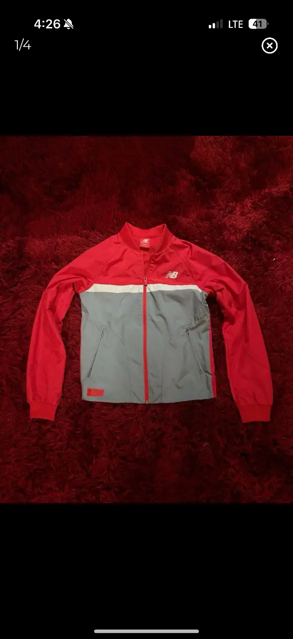 Campera deportiva New Balance para mujer, color rojo y gris. Con cierre y bolsillos.