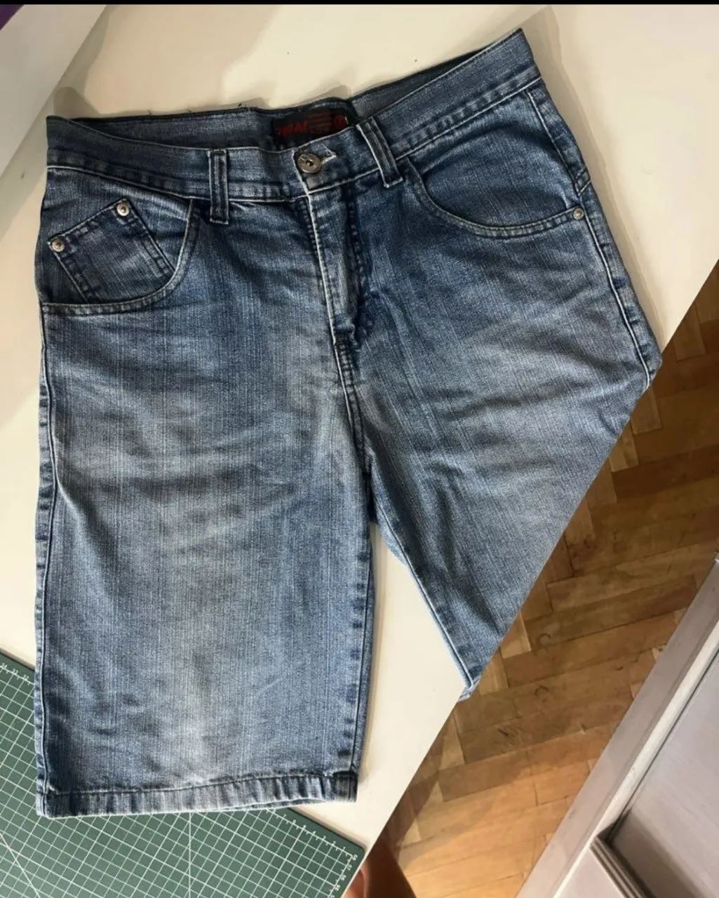 bermuda de jean azul, con bolsillos delanteros y traseros. Talle 42. Ideal para un look casual y cómodo.