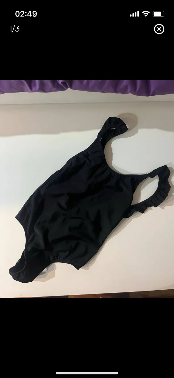 Traje de baño enterizo negro con volados en los hombros. Con espalda baja. Ideal para la playa o la pileta.