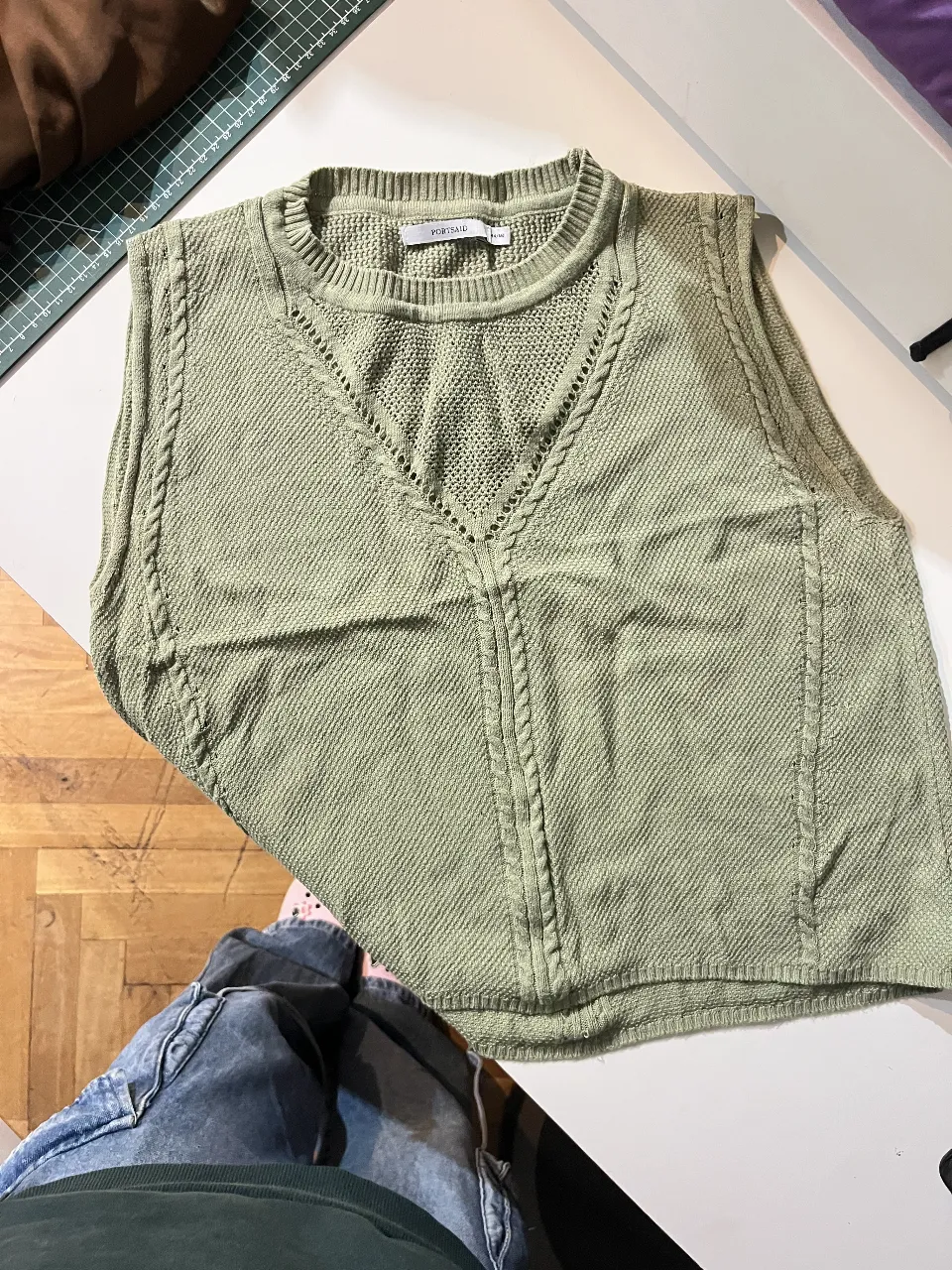 Chaleco tejido de punto, color verde claro, con detalles de diseño en el frente. Ideal para un look casual y moderno.